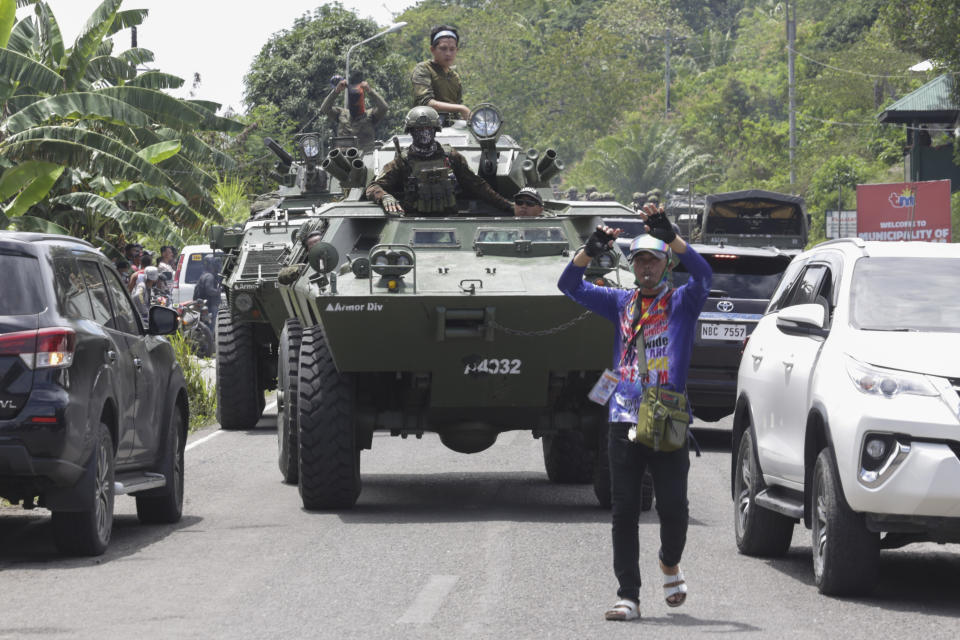 Armored personnel carriers make their way along traffic as they augment security forces in Datu Paglas, Maguindanao province, southern Philippines on Saturday May 8, 2021. Dozens of Muslim militants occupied a public market overnight in the southern Philippines before fleeing after a tense standoff with government forces, officials said Saturday. (AP Photo/Ferdinandh Cabrera)