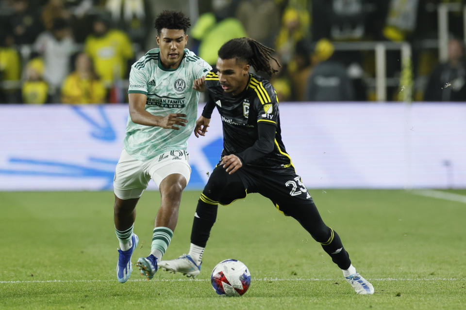 Columbus Crew's Mohamed Ramzdine Farsi, right, controls the ball as Atlanta United's Caleb Wiley defends during the first half of an MLS playoff soccer match Sunday, Nov. 12, 2023, in Columbus, Ohio. (AP Photo/Jay LaPrete)