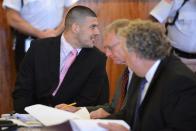 Aaron Hernandez speaks with his lawyers his lawyers, Charles Rankin (C) and Michael Fee (R) during a hearing in Suffolk Superior Court in Boston, Massachusetts, July, 8, 2014. A Massachusetts judge agreed on Monday to transfer former National Football League star Aaron Hernandez to a state jail near Boston and closer to his lawyers as he prepares for two trials where he will face charges of murdering three men. REUTERS/Josh Reynolds/POOL (UNITED STATES - Tags: CRIME LAW SPORT FOOTBALL)