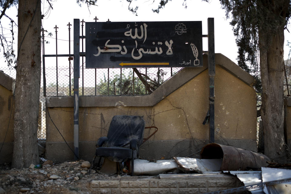 In this July 15, 2018 photo, an Islamic slogan in Arabic reads, "Do not forgot to mention God," is painted on a placard in the abandoned Tawbeh Prison, where over the years the Army of Islam detained hundreds of people, Douma, Syria. The fate of activist Razan Zaitouneh is one of the longest-running mysteries of Syria’s civil war. There’s been no sign of life, no proof of death since gunmen abducted her and three of her colleagues from her offices in the rebel-held town of Douma in 2013. Now Douma is in government hands and clues have emerged that may bring answers. (AP Photo/Hassan Ammar)
