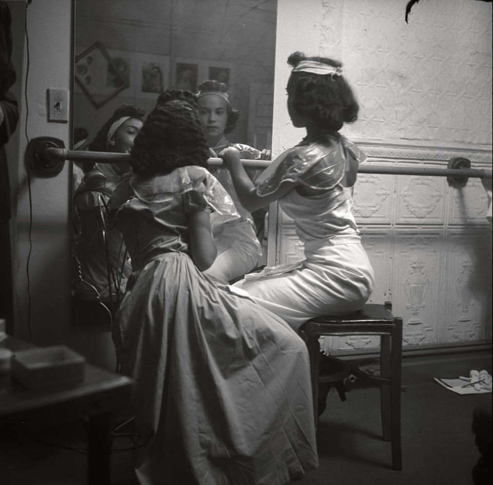 Two young black models check their make-up backstage. Harlem, New York City, USA. 1950.