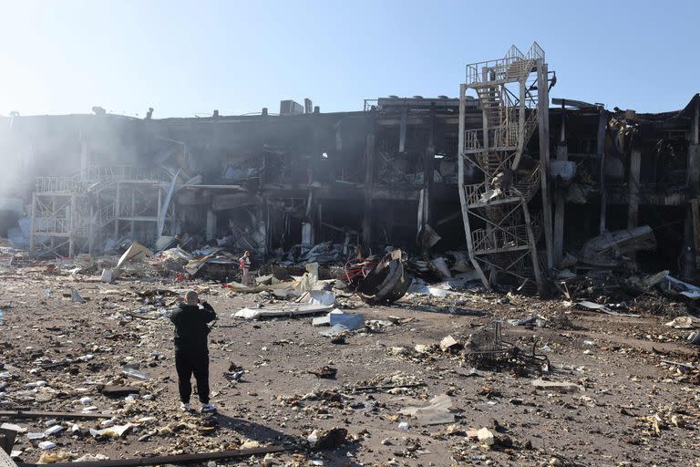 Un hombre toma fotografías del centro comercial y de entretenimiento en la ciudad ucraniana de Odessa, en el Mar Negro, el 10 de mayo de 2022, destruido después del ataque de misiles rusos el 9 de mayo de 2022. (Foto de Oleksandr GIMANOV / AFP)