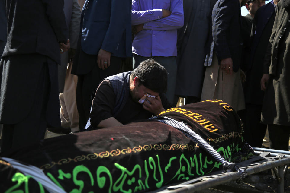 A man cries over the body of a victim of deadly bombings on Saturday near a school, at a cemetery west of Kabul, Afghanistan, Sunday, May 9, 2021. The Interior Ministry said Sunday the death toll in the horrific bombing at the entrance to a girls' school in the Afghan capital has soared to some 50 people, many of them pupils between 11 and 15 years old, and the number of wounded in Saturday's attack has also climbed to more than 100. (AP Photo/Mariam Zuhaib)