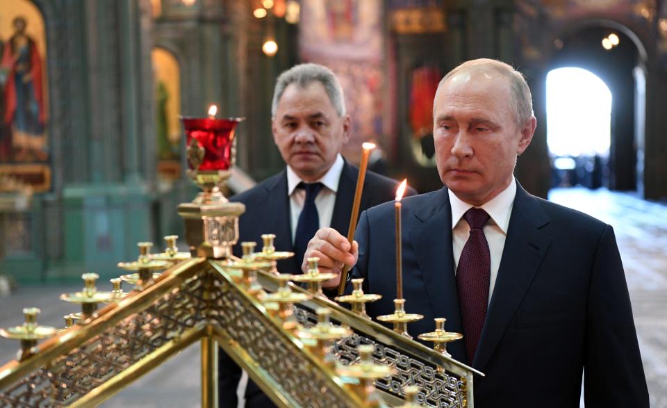 FILE - In this file photo taken on Monday, June 22, 2020, Russian President Vladimir Putin, right, with Russian Defense Minister Sergei Shoigu, lights a candle after a religion service marking the 79th anniversary of the Nazi invasion of the Soviet Union, at the Cathedral of Russian Armed Forces in the Patriot Park outside Moscow, Russia. A massive military parade that was postponed by the coronavirus will roll through Red Square this week to celebrate the 75th anniversary of the end of World War II in Europe, even though Russia is continuing to register a steady rise in infections. (Alexei Nikolsky, Sputnik, Kremlin Pool Photo via AP, File)