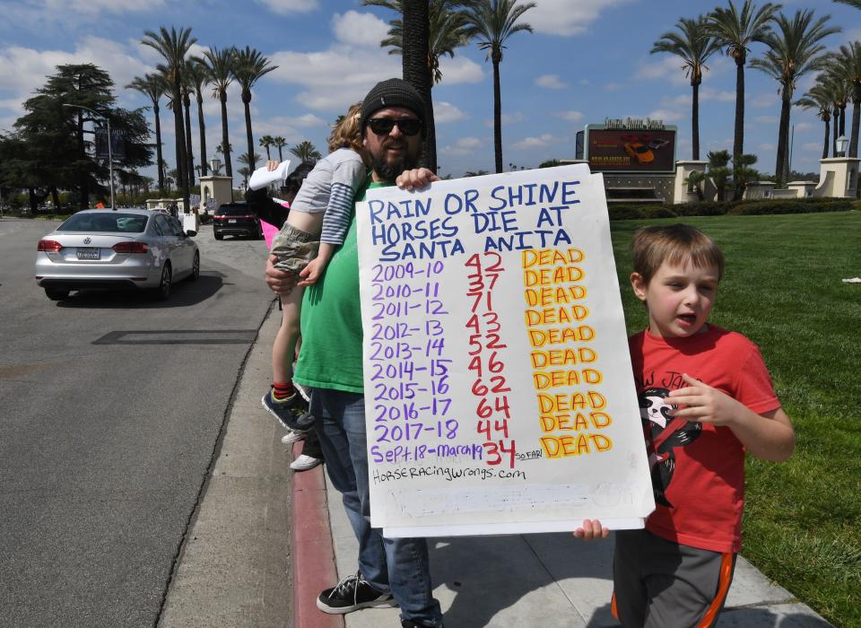 Animal-rights advocates protest beside the entrance gate, the deaths of 23 racehorses in the first three months of this year at the Santa Anita Racetrack in Arcadia, California. (Getty Images)