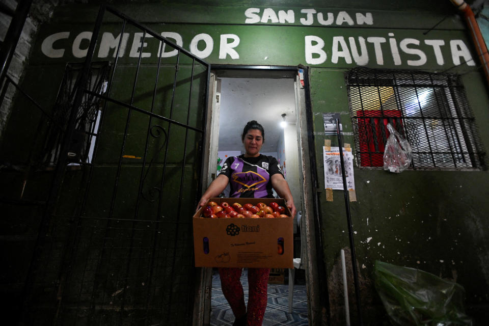 María Liliana Benítez Osorio, de 36 años, quien ayuda en un comedor social como cocinera voluntaria, camina con una caja con manzanas en el comedor social San Juan Bautista, en Villa Soldati, en las afueras de Buenos Aires, Argentina, el 10 de septiembre de 2024. REUTERS/Mariana Nedelcu/Foto de archivo