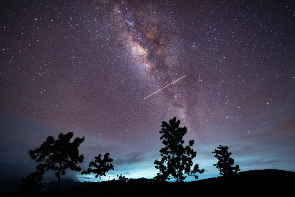 A flight-illuminated path and the Milky Way are appearing in the night sky during the Eta Aquarids meteor shower, which is peaking in Ratnapura, Sri Lanka, on May 5, 2024.  / Credit: Thilina Kaluthotage/NurPhoto via Getty Images