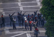 In this March 4, 2021, file photo, police officers aim guns towards people in nearby apartments as they stand off with anti-coup protesters in Yangon, Myanmar. Myanmar's security forces have killed scores of demonstrators protesting a coup. The outside world has responded so far with tough words, a smattering of sanctions and little else. (AP Photo, File)