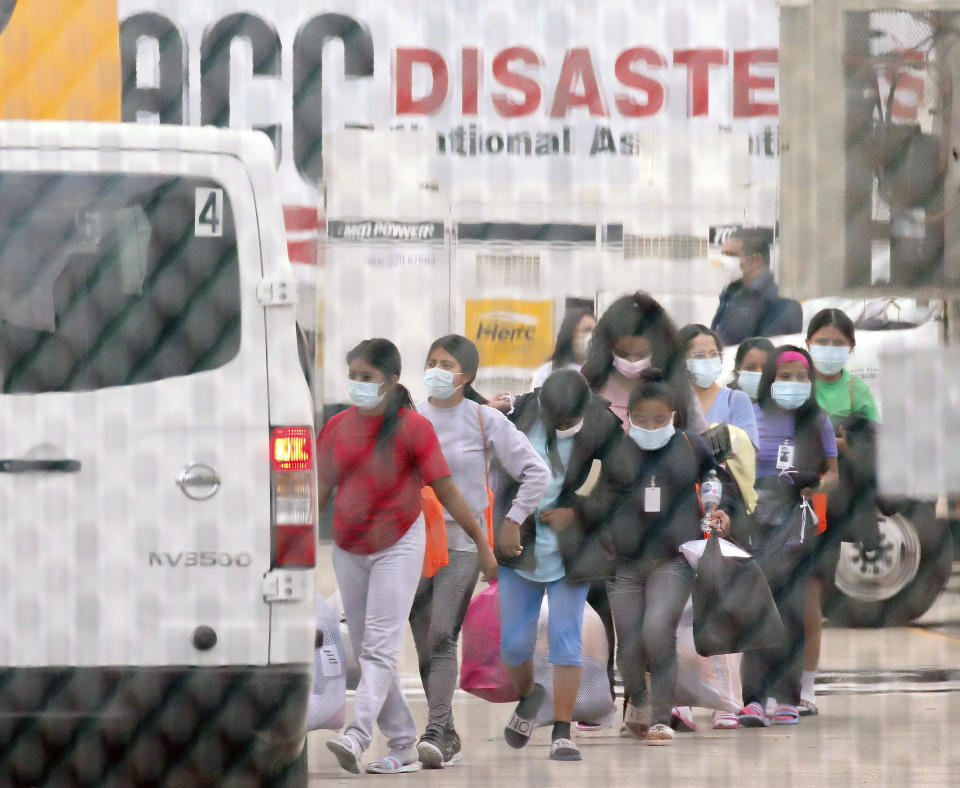 FILE - In this April 17, 2021 file photo, teenage migrant girls are loaded into vans to be transported out of the National Association of Christian Churches facility in Houston. The Biden administration is holding tens of thousands of asylum-seeking children in an opaque network of some 200 facilities that The Associated Press has now learned spans two dozen states and includes five shelters with more than 1,000 children packed inside. (Godofredo A. Vásquez/Houston Chronicle via AP, File)