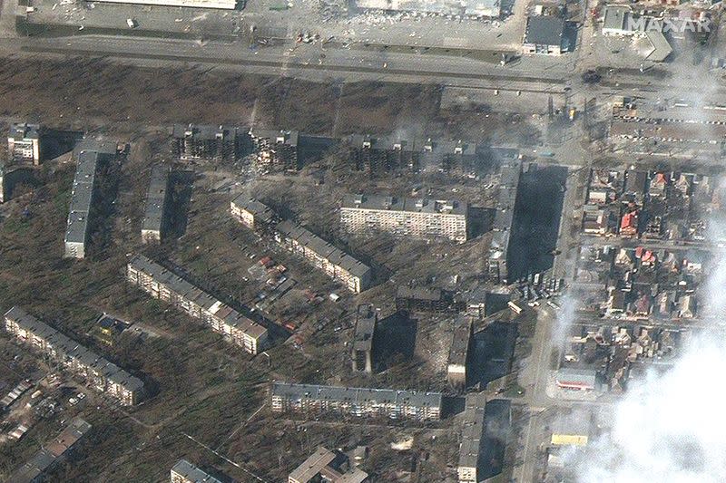 Burning, heavily damaged apartment buildings and stores in Mariupol