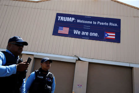 Local police greet U.S. President Donald Trump and first lady Melania Trump as they arrive aboard Air Force One, to survey hurricane damage, at Muniz Air National Guard Base in Carolina, Puerto Rico, U.S. October 3, 2017. REUTERS/Jonathan Ernst