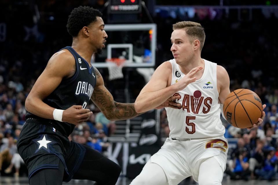 Cleveland Cavaliers' Sam Merrill (5) looks to pass the ball as Orlando Magic's Caleb Houstan, left, defends during the first half of a game April 6 in Orlando, Fla.