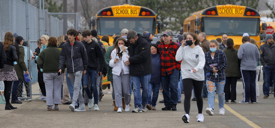 Parents walk away with their kids from the Meijer's parking lot, where many students gathered following an active shooter situation at Oxford High School. Source: AP/AAP