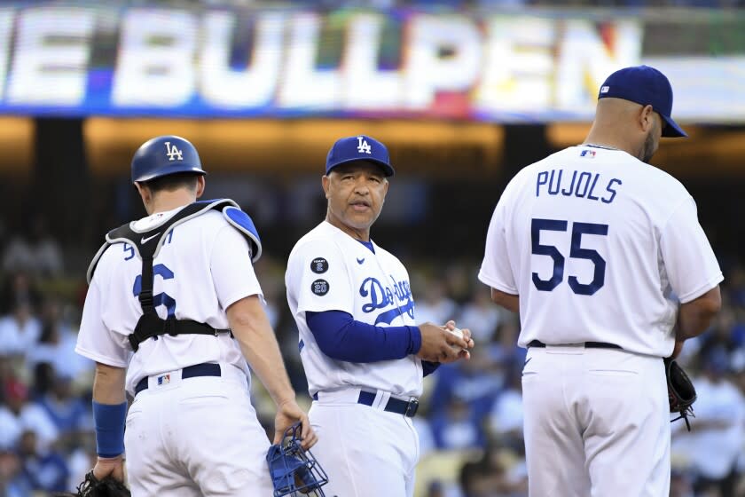 Los Angeles, CA - October 21: Los Angeles Dodgers manager Dave Roberts, center, waits on the pitching mound with Los Angeles Dodgers' Will Smith, left, and Albert Pujols while waiting for the bullpen during a pitching change during the first inning in game five in the 2021 National League Championship Series against the Atlanta Braves at Dodger Stadium on Thursday, Oct. 21, 2021 in Los Angeles, CA. (Wally Skalij / Los Angeles Times)