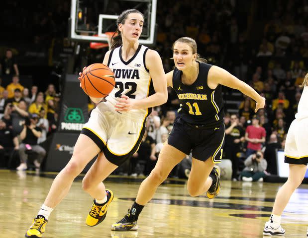 <p>Matthew Holst/Getty</p> Guard Caitlin Clark #22 of the Iowa Hawkeyes drives against guard Greta Kampschroeder #11the Michigan Wolverines during the second half at Carver-Hawkeye Arena on February 15, 2024 in Iowa City, Iowa.