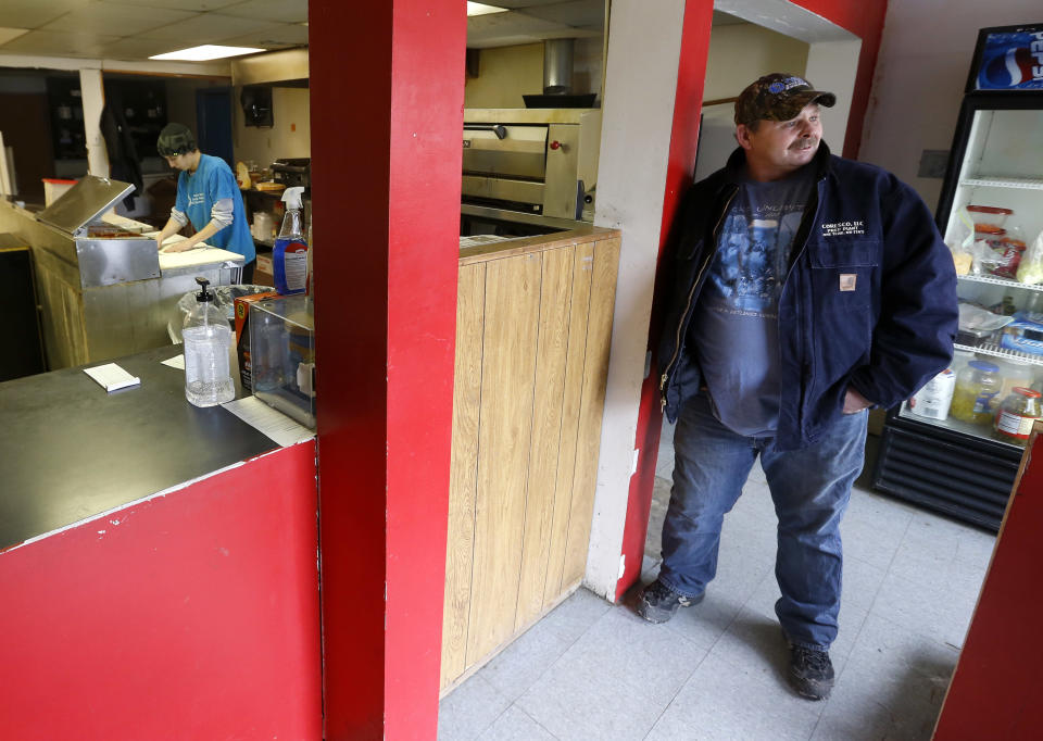 In this photo made on Saturday, March 1, 2014, Ray Elli, right, talks about how area people reacted when they received a certificate for free pizza from the local shop at Bobtown Pizza in Bobtown, Pa. The little pizza shop in the southwestern corner of Pennsylvania was placed in the spotlight when energy giant Chevron offered coupons for free pizza to people who live near the area where a natural gas well that exploded, killing one worker on Feb 11, 2014. Some news stories and internet opinion posts have been critical about the offer by Chevron Corp., but many residents of the town said they didn’t mind the pizza offer. (AP Photo/Keith Srakocic)