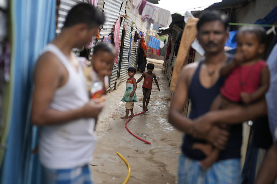 Children play in a narrow lane of a poor community in Bengaluru, India, Tuesday, July 19, 2022. In this community, most people are from Assam state, many forced to migrate because of climate change and dreaming of a better future. (AP Photo/Aijaz Rahi)