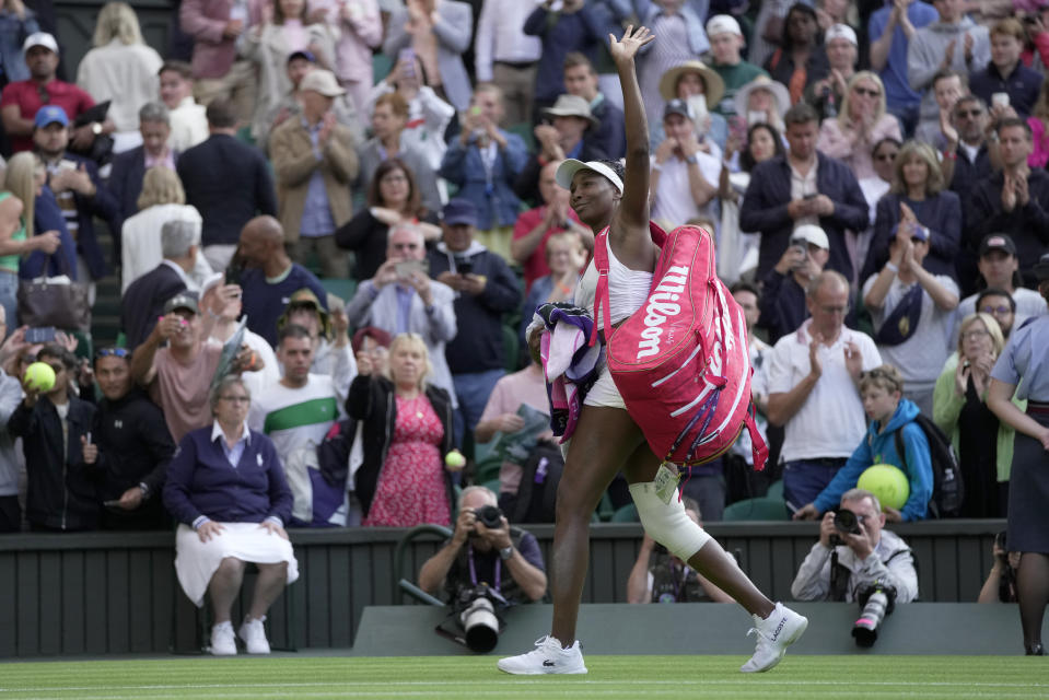 Venus Williams of the US waves as she leaves the court after losing to Ukraine's Elina Svitolina in a first round women's singles match on day one of the Wimbledon tennis championships in London, Monday, July 3, 2023. (AP Photo/Kin Cheung)