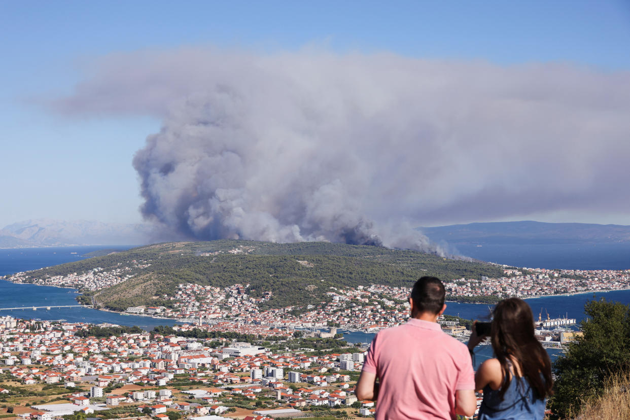 People watch the wildfire on the island Ciovo, from Seget Gornji, Croatia, July 27, 2023. REUTERS/Antonio Bronic