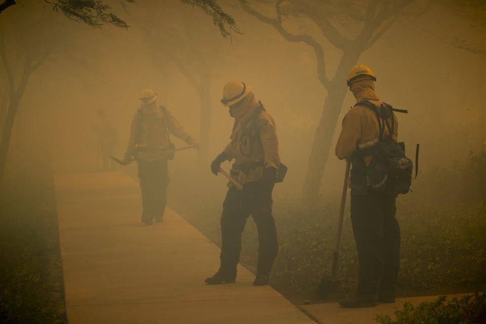 Firefighters brave hot wind and approaching flames in Irvine