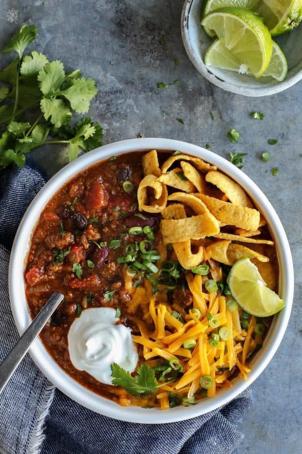 slow cooker beef chili overhead with corn chips and cheese