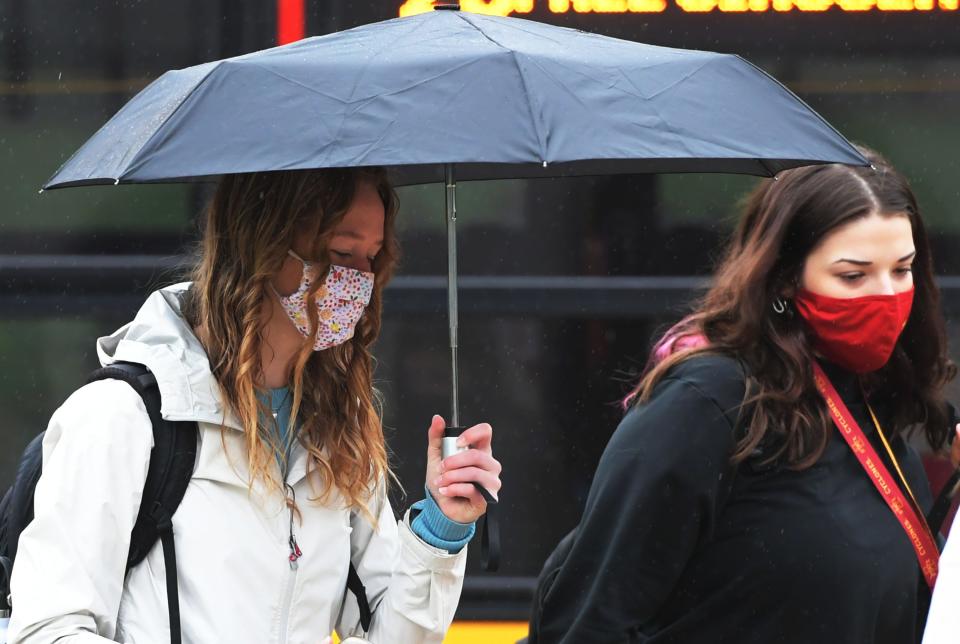Iowa State University students walk in the university's central campus wearing face masks on Thursday.