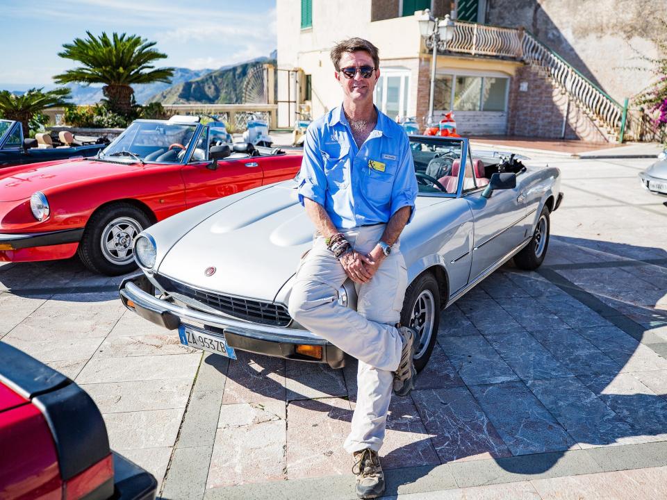 A person sitting on a vintage car.