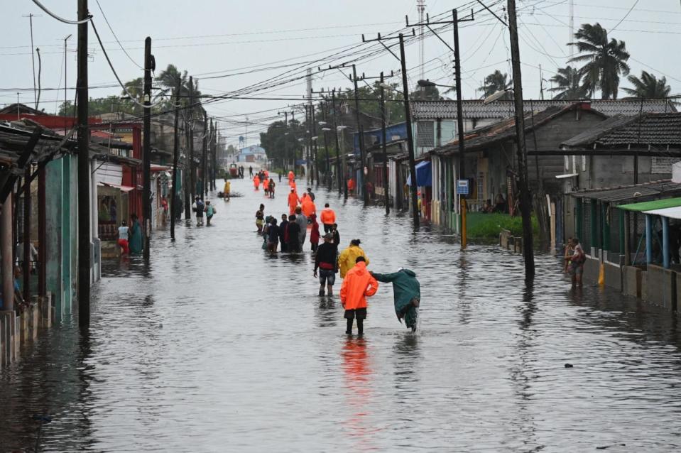 PHOTO: People walk through a flooded street in Batabano, Mayabeque province, Cuba, Aug. 29, 2023, during the passage of tropical storm Idalia. (Yamil Lage/AFP via Getty Images)