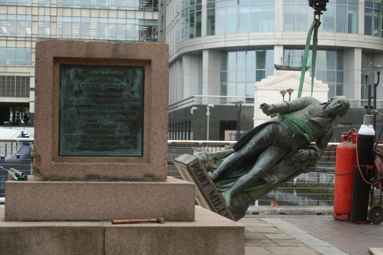 Workers prepare to take down a statue of slave owner Robert Milligan at West India Quay, east London as Labour councils across England and Wales will begin reviewing monuments and statues in their towns and cities, after a protest saw anti-racism campaigners tear down a statue of a slave trader in Bristol.