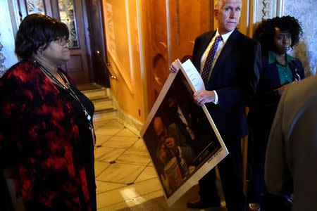 Sen. Thom Tillis (R-NC) arrives at the Senate Chamber on Capitol Hill with a print of Rep. Steve Cohen (D-TN) eating Kentucky Fried Chicken at a House Judiciary Committee hearing that U.S. Attorney General William Barr was due to attend in Washington, D.C., U.S., May 2, 2019. REUTERS/Clodagh Kilcoyne
