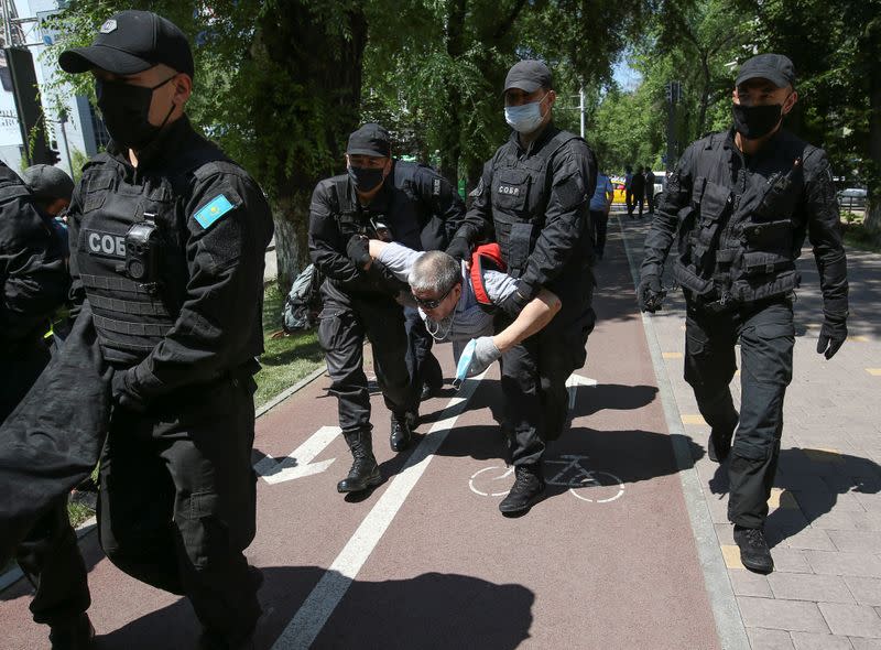 Kazakh law enforcement officers detain a man during an opposition rally in Almaty