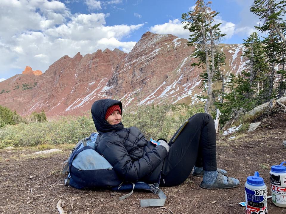 Woman lying on her backpack in the mountains