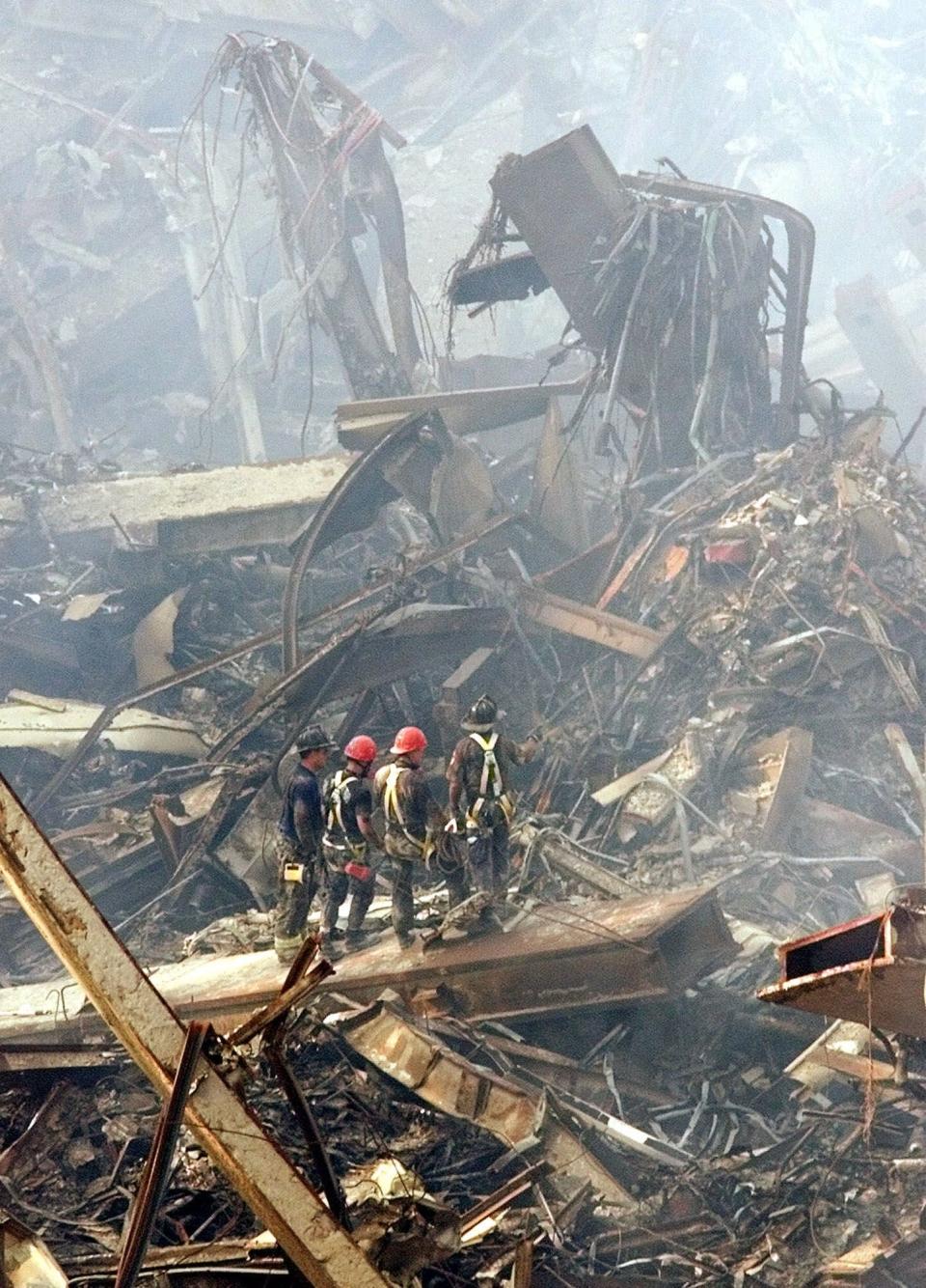 Emergency workers stand on a girder at the site of the destroyed World Trade Center towers, which still smoked in this photo taken 10 days after the 9/11 terror attack.