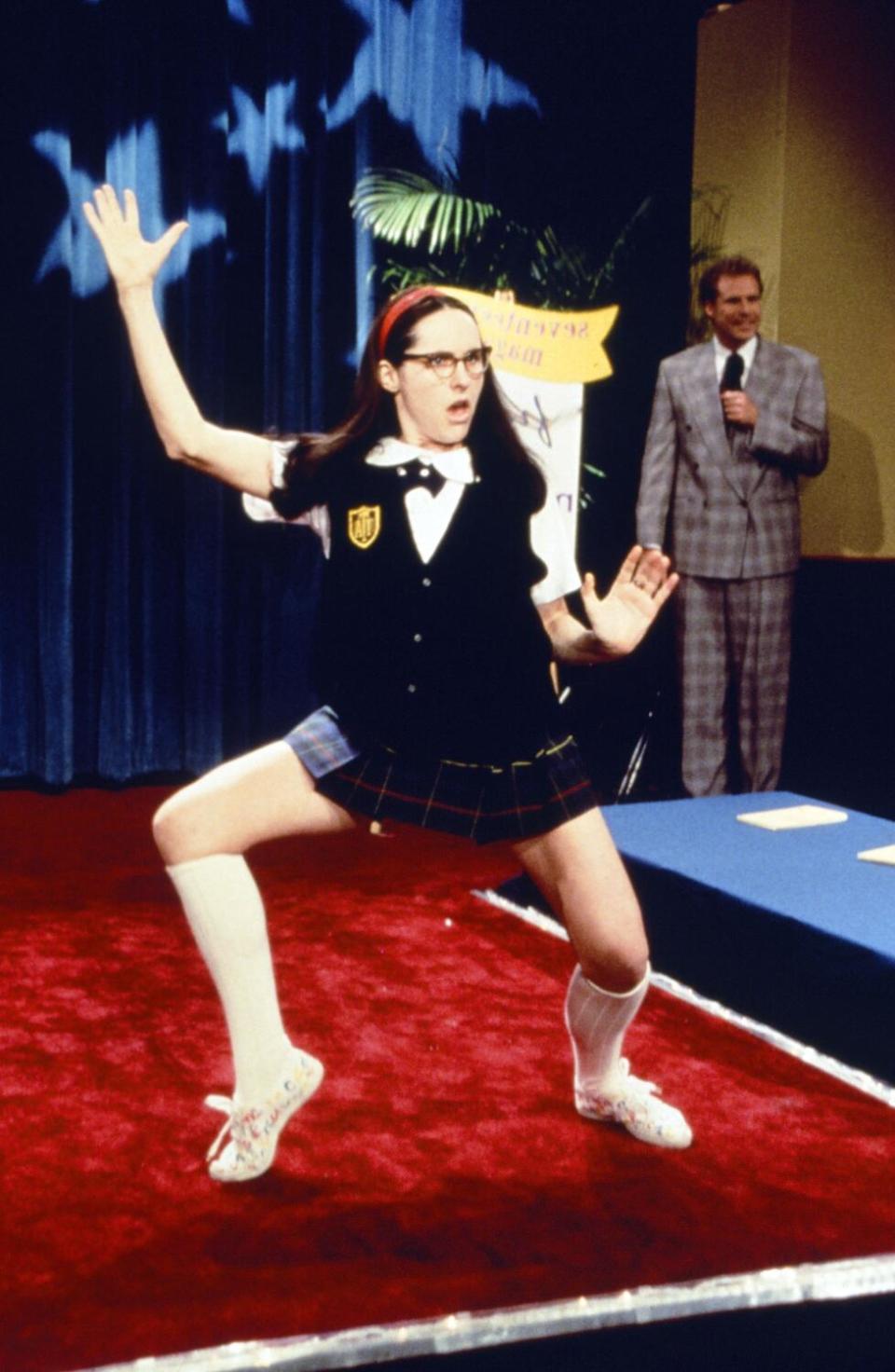 Molly Shannon strikes a pose in a school uniform while Will Ferrell stands to the side in a suit