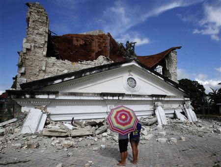 Residents look at a collapsed Holy Trinity parish church at Loay, Bohol after an earthquake struck central Philippines October 17, 2013. REUTERS/Erik De Castro