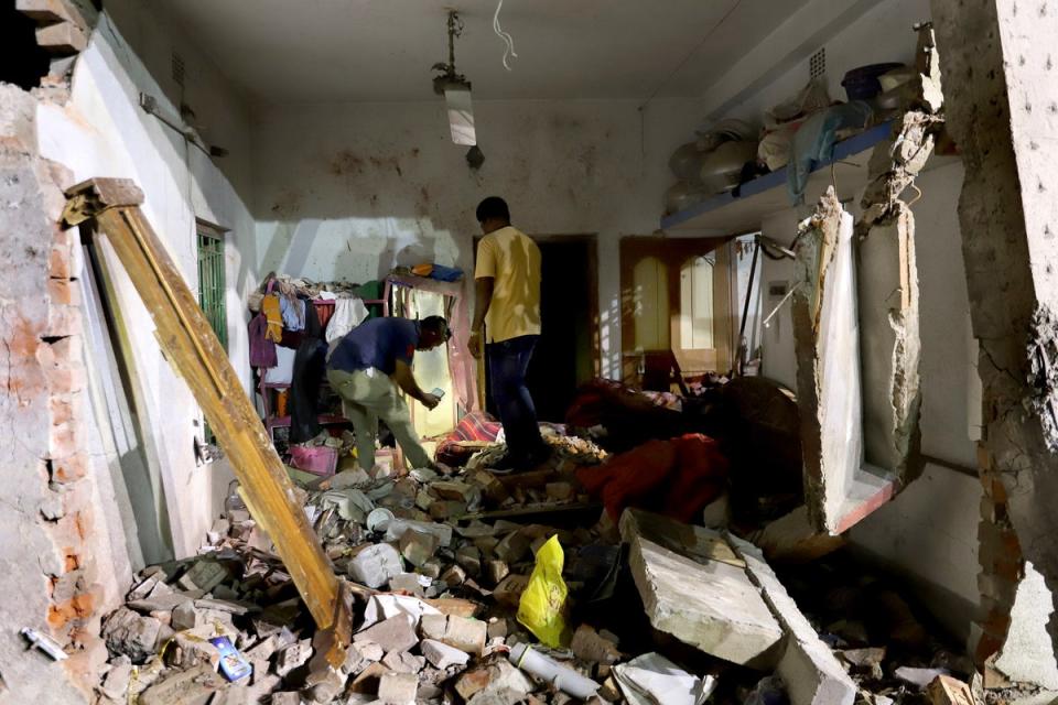 Residents inspect their damaged home after a massive explosion occurred at a firecracker factory in Duttapukur village (EPA)