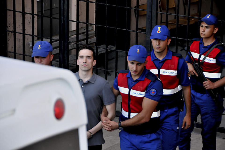 Turkish paramilitary police officers escort Greek soldier Aggelos Mitretodis following a court appearance in Edirne, Turkey, Tuesday, Aug. 14, 2018. Turkey on Tuesday released from prison two Greek soldiers held since March 1 for allegedly illegally crossing the border between the two countries, in a move hailed by Greece's prime minister as "an act of justice." (DHA via AP )