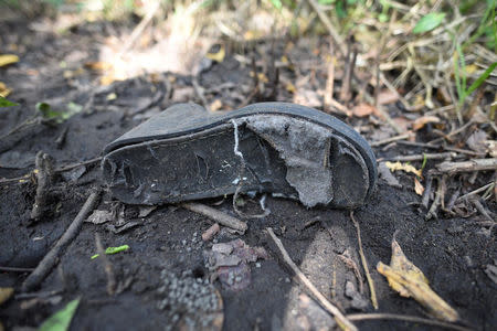 A shoe is pictured at the site of unmarked graves where a forensic team and judicial authorities are working in after human skulls were found, in Alvarado, in Veracruz state, Mexico, March 19, 2017. REUTERS/Yahir Ceballos