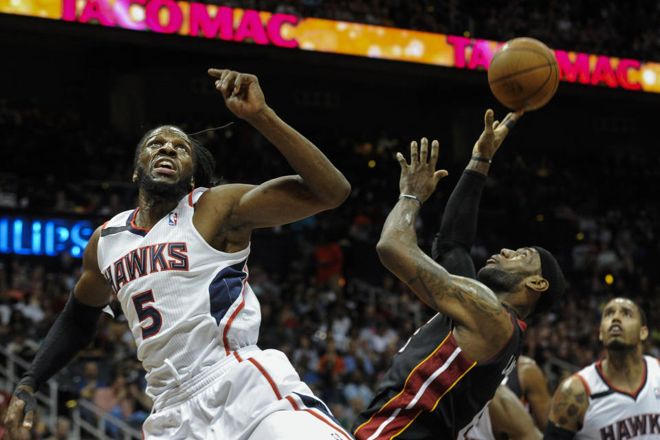 Miami Heat forward LeBron James, front right, is fouled under the basket by Atlanta Hawks forward DeMarre Carroll (5) during the first half of an NBA basketball game on Saturday, April 12, 2014, in Atlanta. (AP Photo/John Amis)