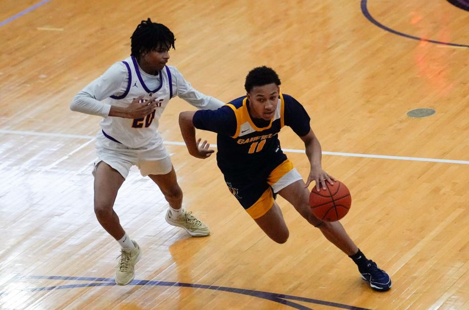 Reynoldsburg's Tejuan Barbour (20) guards Garfield Heights Marcus Johnson (11) during the Jared Sullinger Play-By-Play Classic 2024 January in Reynoldsburg.