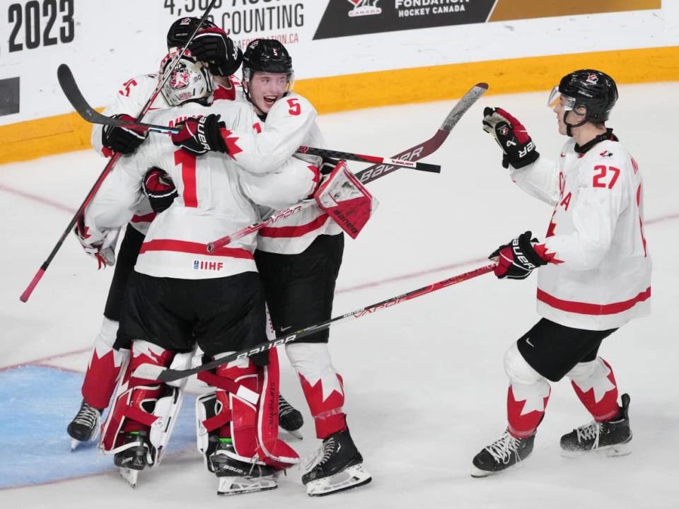 Canadian goalie Thomas Milic (1) is swarmed by teammates after a 6-2 semifinal win over the United States at the world junior hockey championship on Wednesday night in Halifax. (Darren Calabrese/The Canadian Press - image credit)