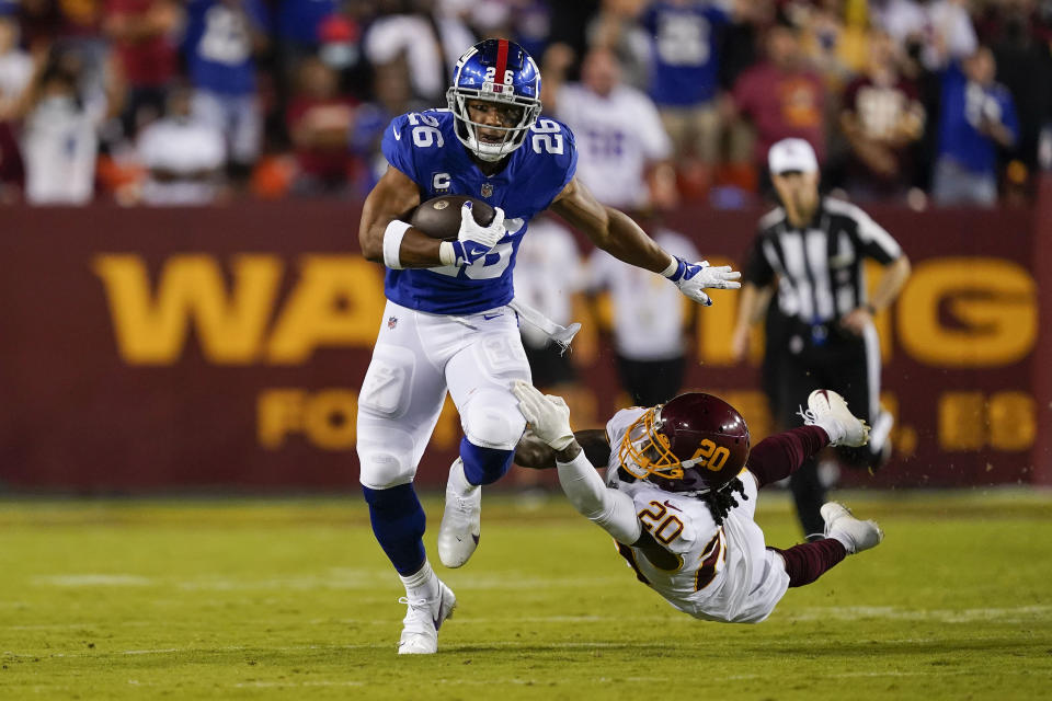 FILE - New York Giants running back Saquon Barkley (26) breaks away from Washington Football Team cornerback Bobby McCain (20) as he runs with the ball during the first half of an NFL football game, Thursday, Sept. 16, 2021, in Landover, Md. New coach Brian Daboll needs to fix the offense and get quarterback Daniel Jones and running back Saquon Barkley going. (AP Photo/Alex Brandon, File)