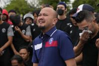 Muhammad Ali Rifky ,center, Manager club of Arema FC reacts after praying for the fans who lost their lives in a stampede Saturday night outside the Kanjuruhan Stadium in Malang, Indonesia, Monday, Oct. 3, 2022. Police firing tear gas at Saturday night's match between host Arema FC of East Java's Malang city and Persebaya Surabaya in an attempt to stop violence triggered a disastrous crush of fans making a panicked, chaotic run for the exits, leaving a large number of people dead, most of them trampled upon or suffocated. (AP Photo/Achmad Ibrahim)