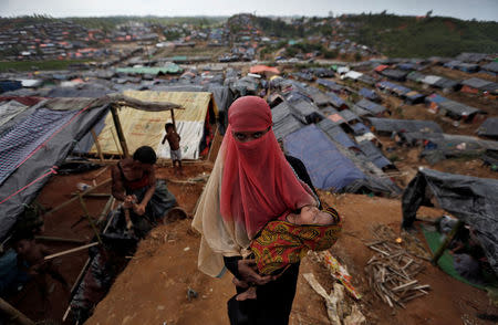 A Rohingya refugee carries her child in a refugee camp in Cox's Bazar, Bangladesh. REUTERS/Cathal McNaughton