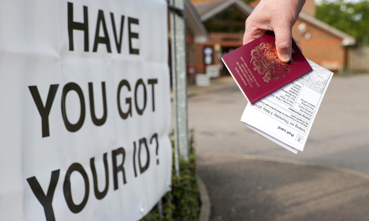 <span>A UK voter carrying a passport. In Belgium, an ID card serves the same purpose.</span><span>Photograph: Andrew Matthews/PA</span>