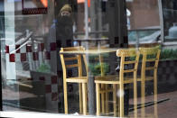 FILE - In this Jan. 17, 2021, file photo, a passerby wearing a protective mask is reflected in the window of an empty restaurant near Market Square in downtown Pittsburgh. Irritated by the sweeping use of executive orders during the COVID-19 crisis, state lawmakers around the U.S. are moving to curb the authority of governors and top health officials to impose emergency restrictions such as mask rules and business shutdowns. (AP Photo/Keith Srakocic, File)