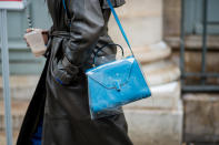 <p>Model carries Valextra Iside blue shoulder bag inside a clear plastic bag. (Photo: Getty Images) </p>