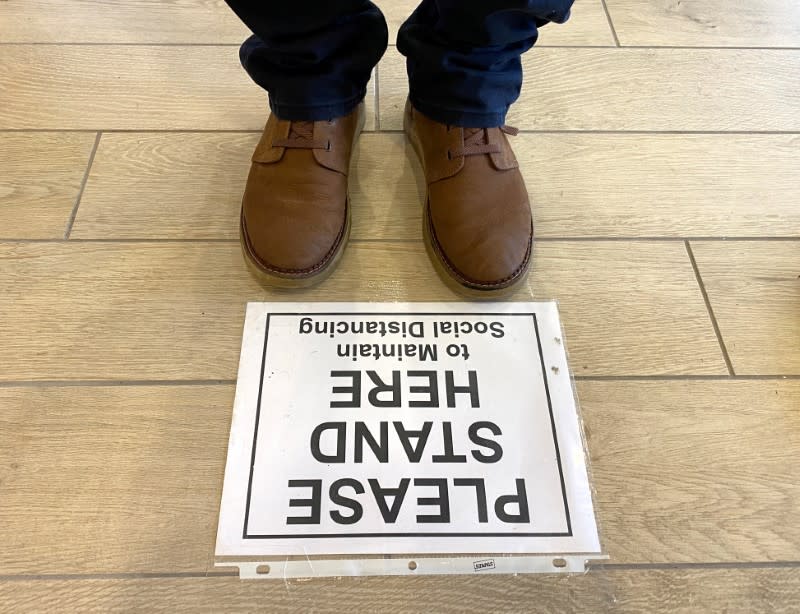 FILE PHOTO: Sign tells bank customers to maintain distance to prevent the spread of coronavirus in Falls Church, Virginia