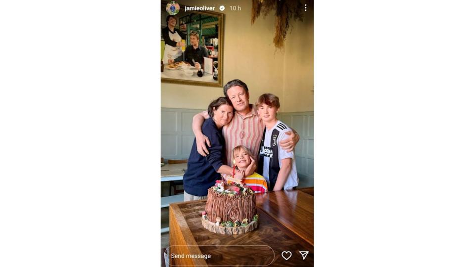 family posing for photo with cake