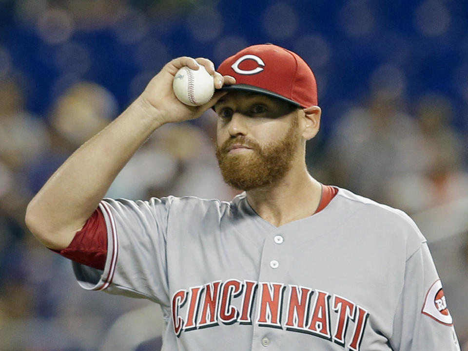 FILE - In this July 8, 2016, file photo, Cincinnati Reds' Dan Straily adjusts his cap after a double by Miami Marlins' Christian Yelich in the first inning of a baseball game in Miami. A person familiar with the negotiations says the Marlins have acquired right-hander Dan Straily from the Cincinnati Reds for three minor leaguers. The person confirmed the trade to The Associated Press on condition of anonymity Thursday, Jan. 19, 2017, because it had not yet been announced. (AP Photo/Alan Diaz, File)